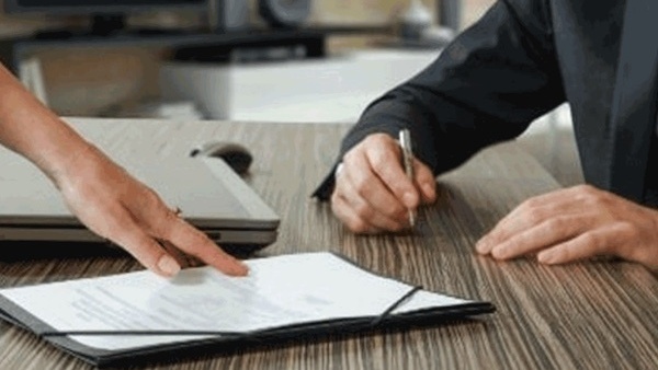 male and female hands working on signing a document
