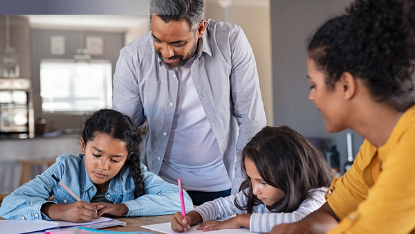 Students writing with adults supervising