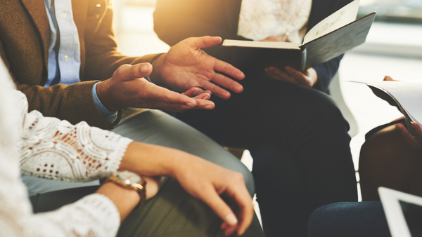 Individuals in a circle focused on peoples hands