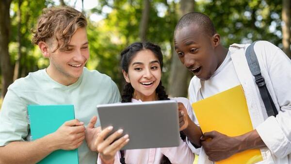 Diverse students looking at a screen in surprise