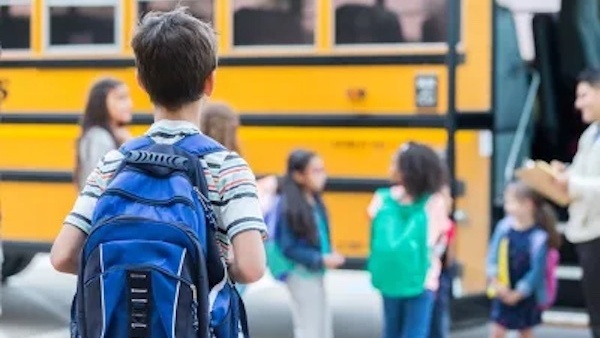 Back of student with bus in blurred background