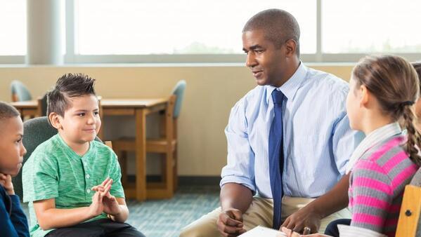 School counselor sitting talking with a group of students