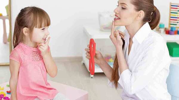 Female speech pathologist  working with a girl