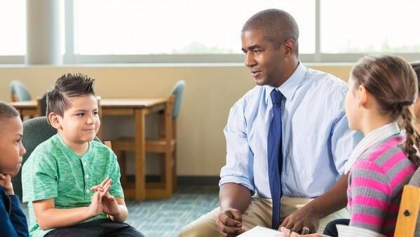 School counselor sitting talking with a group of students