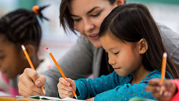 Teacher working with a girl learning English